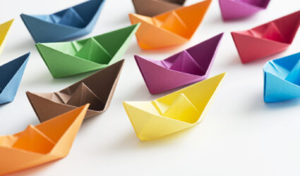 Multicolored paper boats representing new staff
