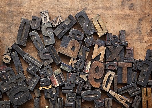 Wood and metal letters and numbers on a burnt backdrop